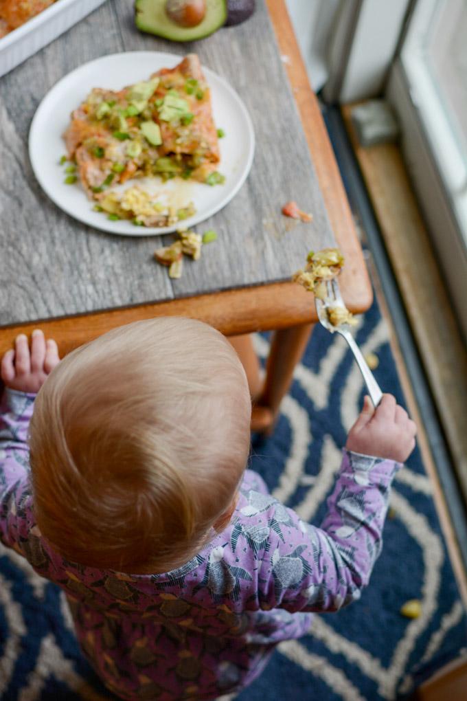 Toddler eating breakfast enchilada casserole