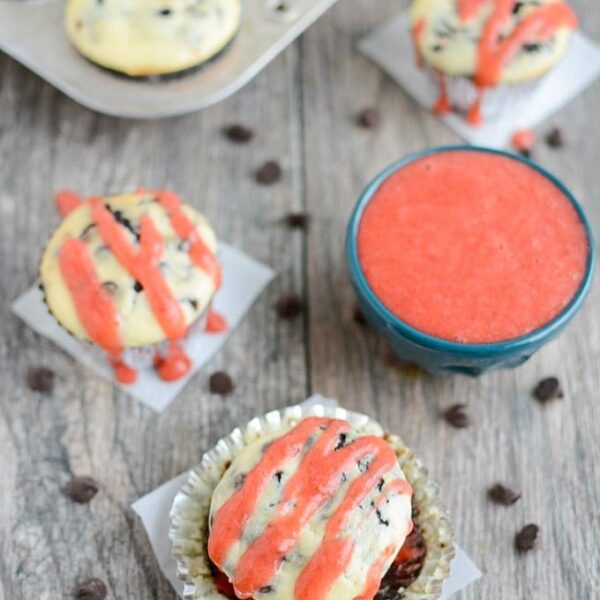 Black Bottom Cheesecake Cupcakes with simple strawberry sauce drizzled on top.