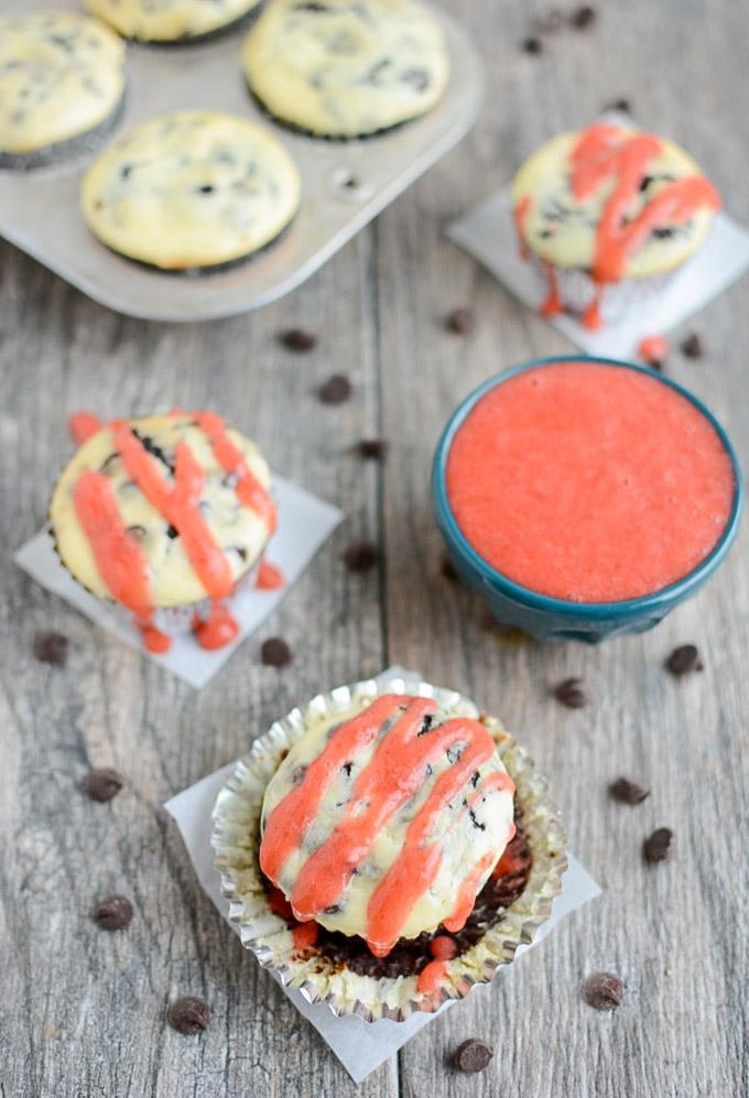 Black Bottom Cheesecake Cupcakes with simple strawberry sauce drizzled on top. 