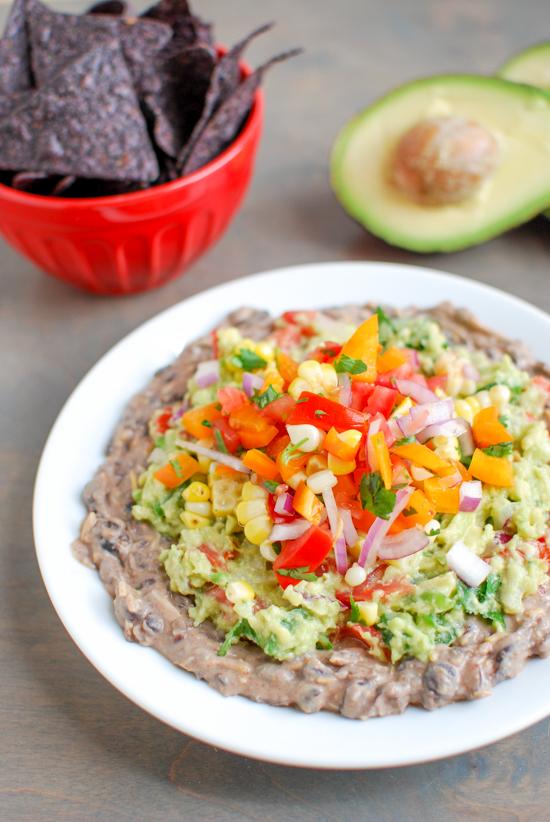 This Mexican Layer Dip is easy to make and full of flavor! With layers of spicy black bean dip, homemade guacamole and fresh corn salsa it's the perfect party appetizer or snack!
