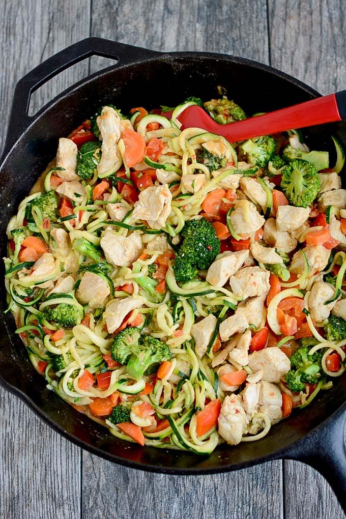 Zucchini Noodles with Chicken and Spicy Almond Butter Sauce in cast iron skillet