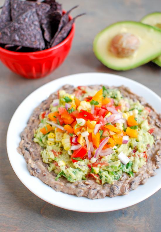 This Mexican Layer Dip is easy to make and full of flavor! With layers of spicy black bean dip, homemade guacamole and fresh corn salsa it's the perfect party appetizer or snack!