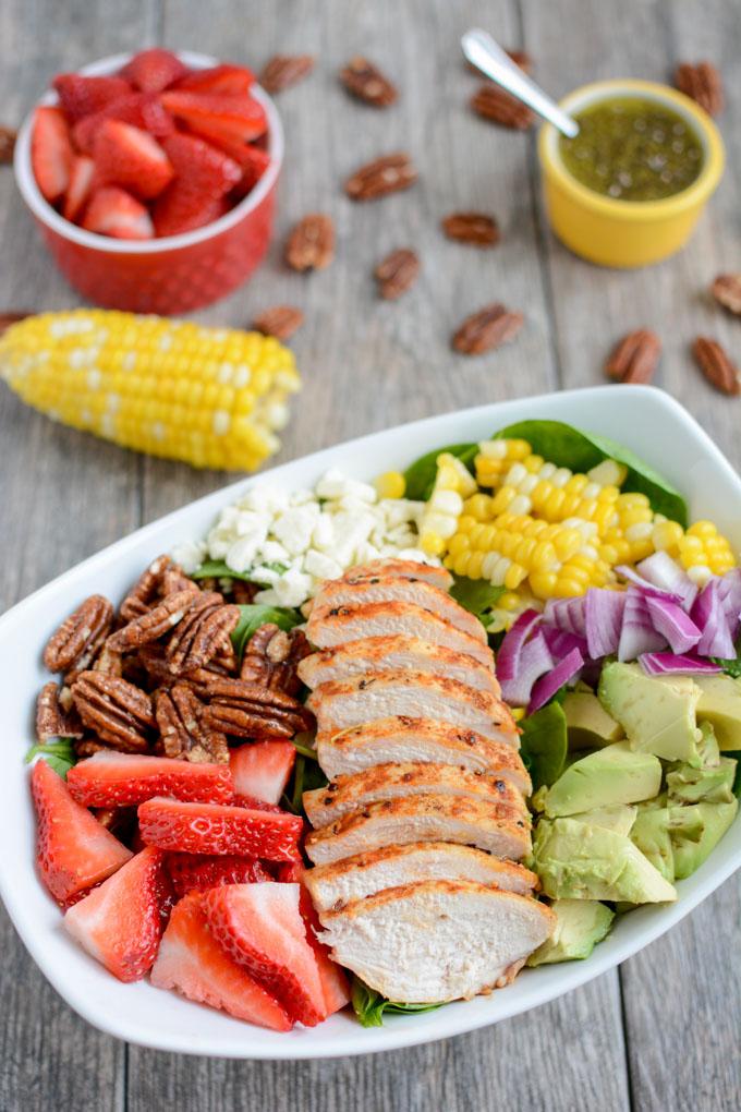 This Strawberry Chicken Spinach Power Salad is perfect for summer! It's packed with protein, fresh produce & nuts and topped with a lemon poppyseed dressing. A great recipe for lunch or dinner!