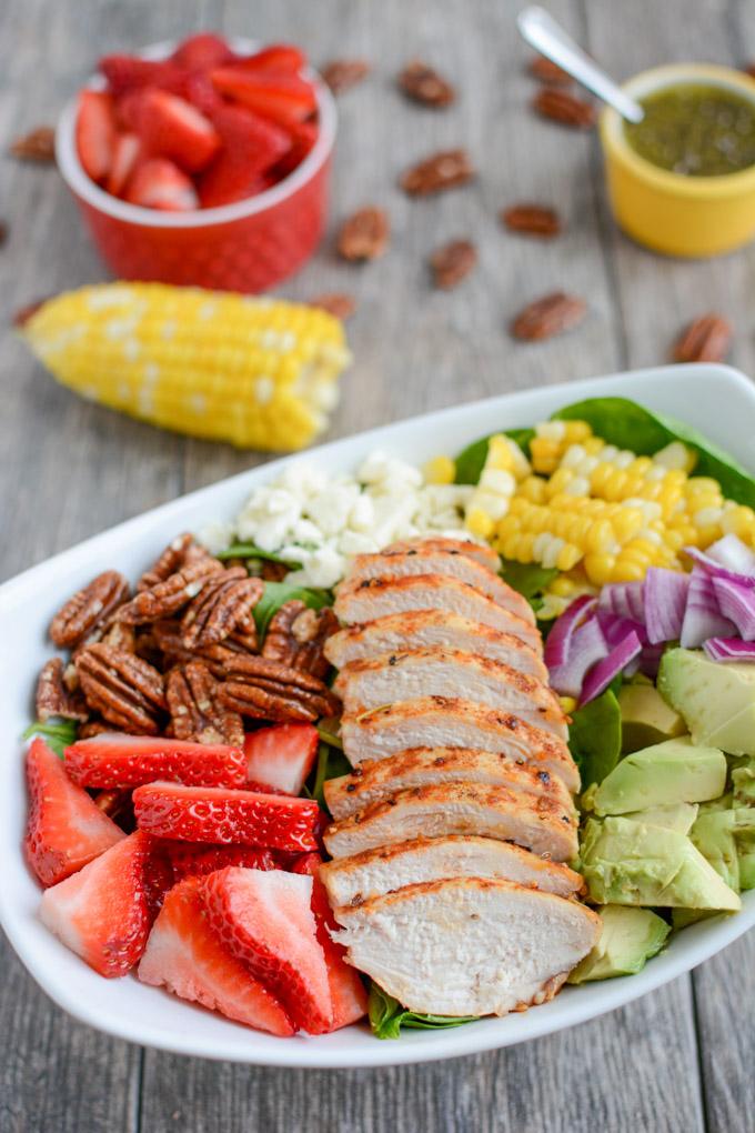 This Strawberry Chicken Spinach Power Salad is perfect for summer! It's packed with protein, fresh produce & nuts and topped with a lemon poppyseed dressing. A great recipe for lunch or dinner!