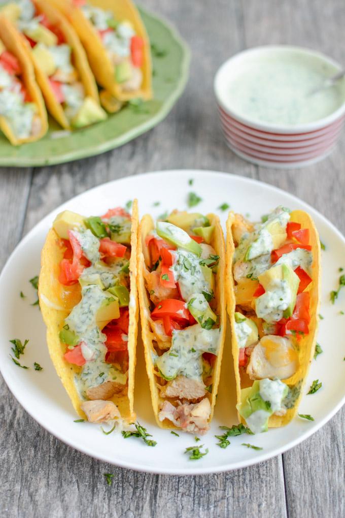 These gluten-free Baked Chicken Tacos with Creamy Cilantro Sauce will quickly become a favorite family dinner recipe! 