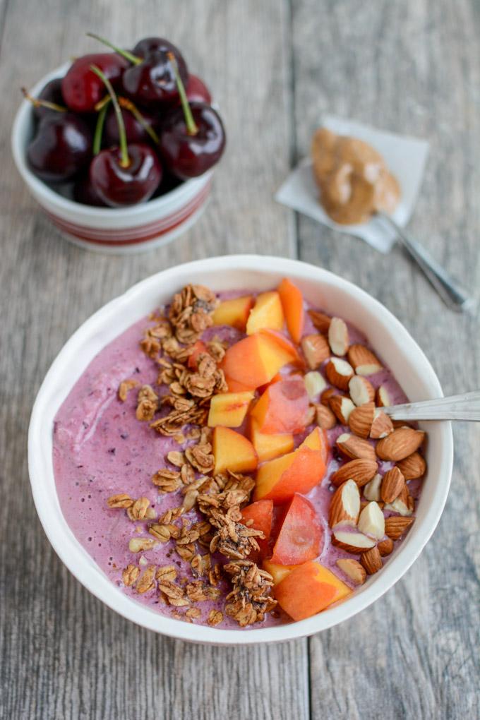 This Cherry Almond Smoothie Bowl recipe is full of healthy fats and protein for a healthy breakfast or snack on a hot day. Top with granola and nuts for an added crunch and dig in with a spoon!