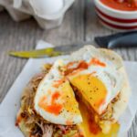 This Pork and Egg Breakfast Pizza is perfect for a late morning football party or tailgating. Cook the pork overnight, then just shred, assemble and top with an egg!