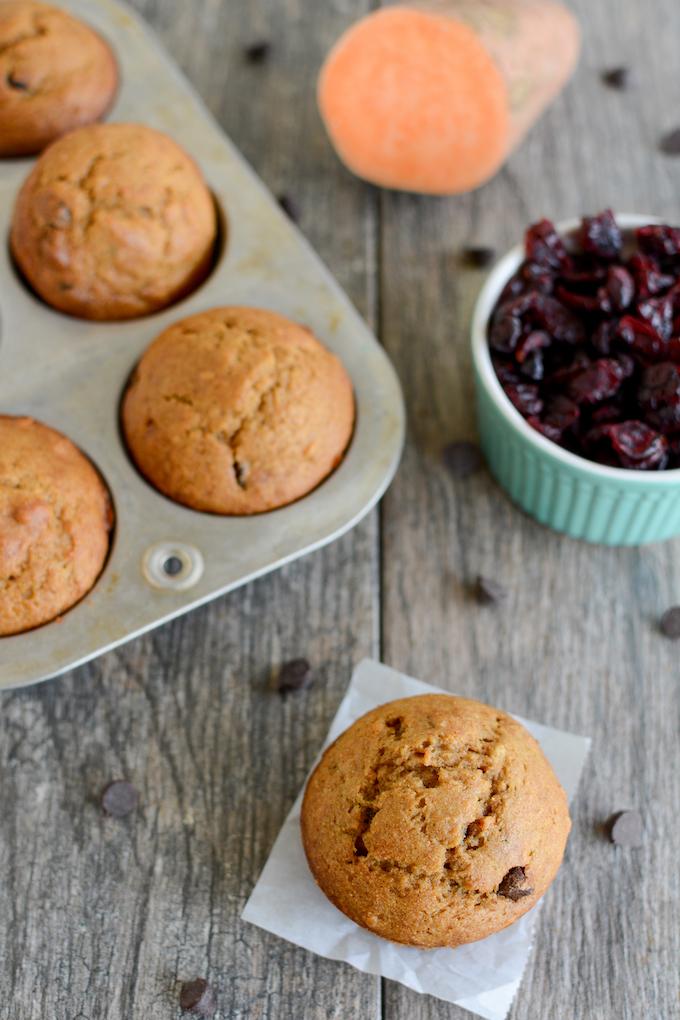 Cranberry Sweet Potato Muffins on parchment paper and in muffin tin