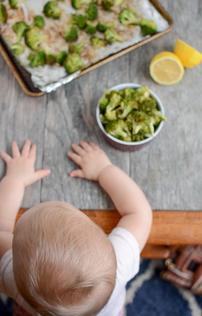 Baby eating lemon roasted broccoli