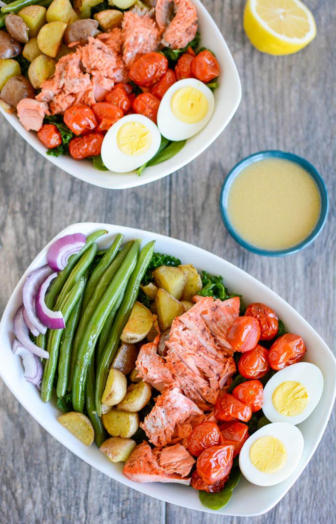 This Salmon Nicoise Salad is an easy, flavorful twist on a classic recipe. Made with roasted vegetables, baked salmon and a simple dressing, it's perfect for a healthy lunch or dinner!