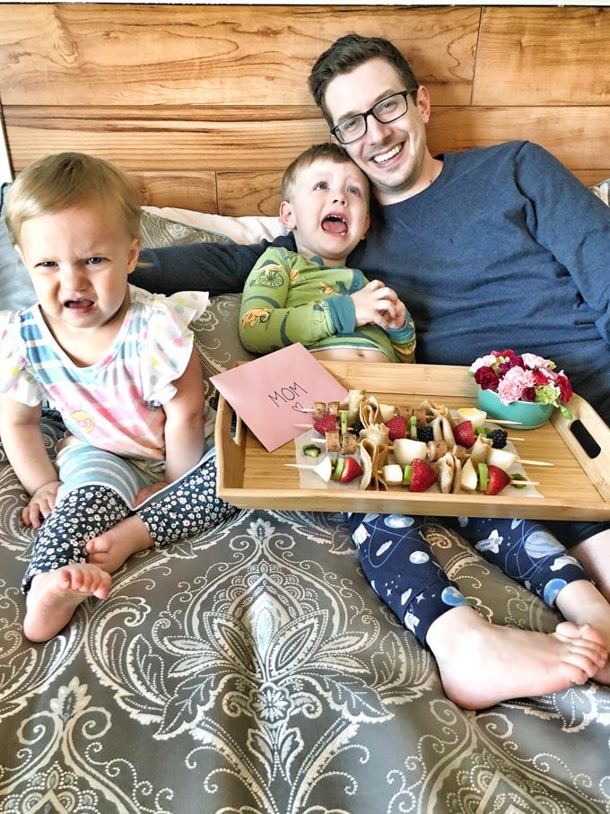 Family serving crepe kabobs to mom in bed for Mother's Day