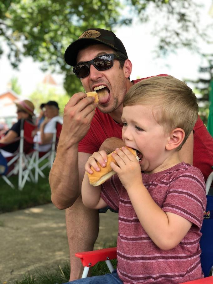 dad and toddler eating hotdog