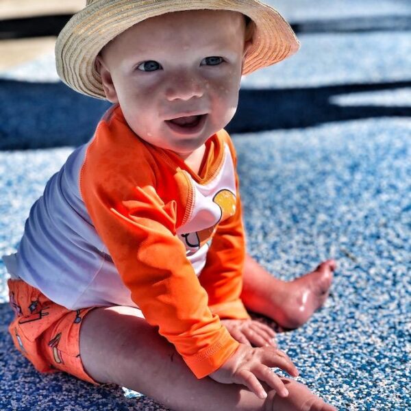 baby sitting at the splash pad