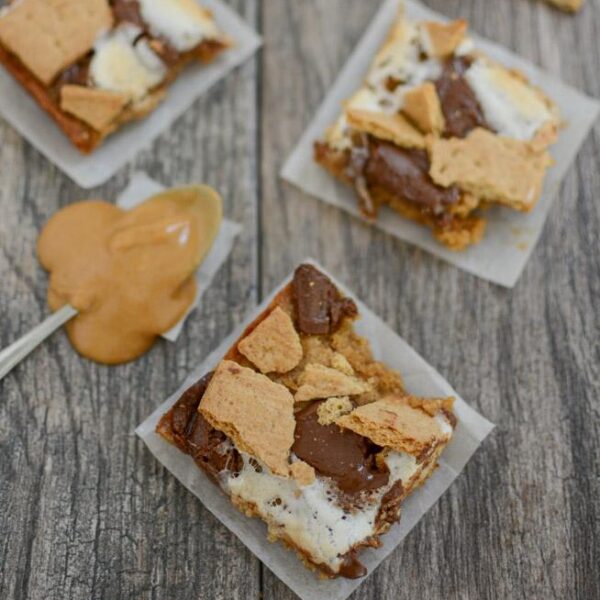 three easy peanut butter s'mores bars with a spoonful of peanut butter