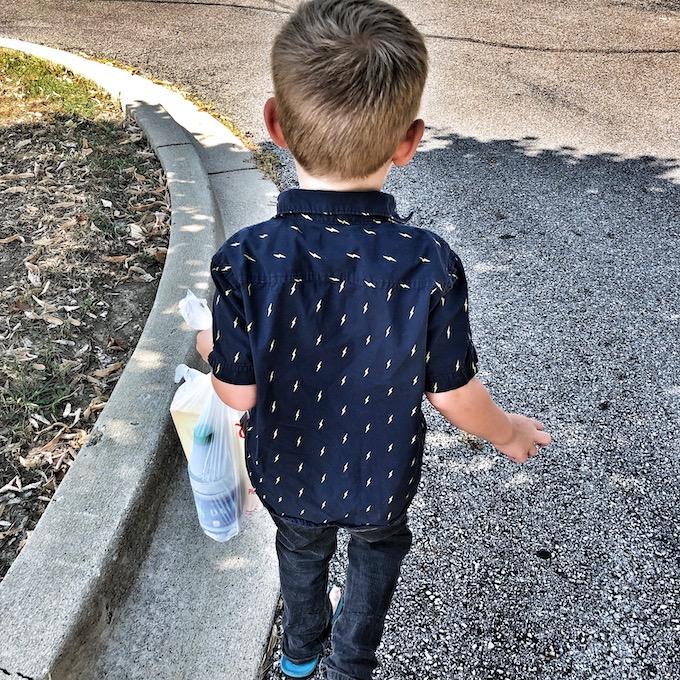 toddler giving bag to person in need