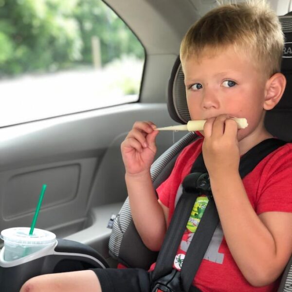 child eating string cheese in the car