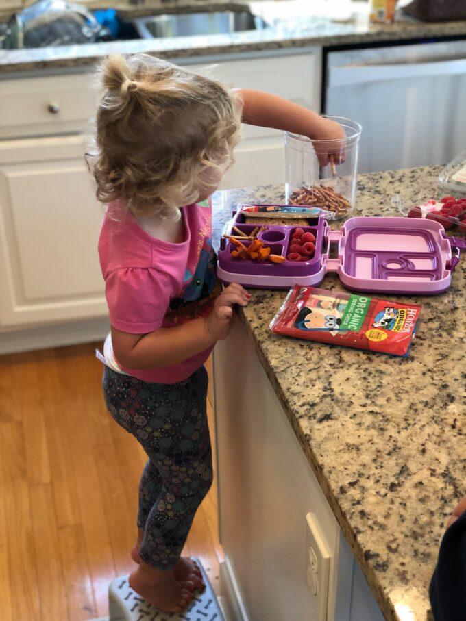 toddler reaching into pretzel jar