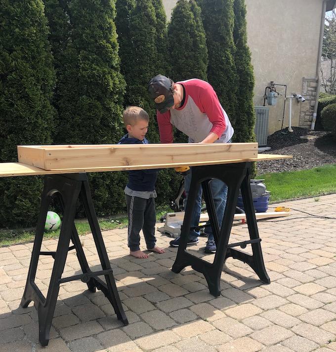 man and son building mud kitchen cooktop
