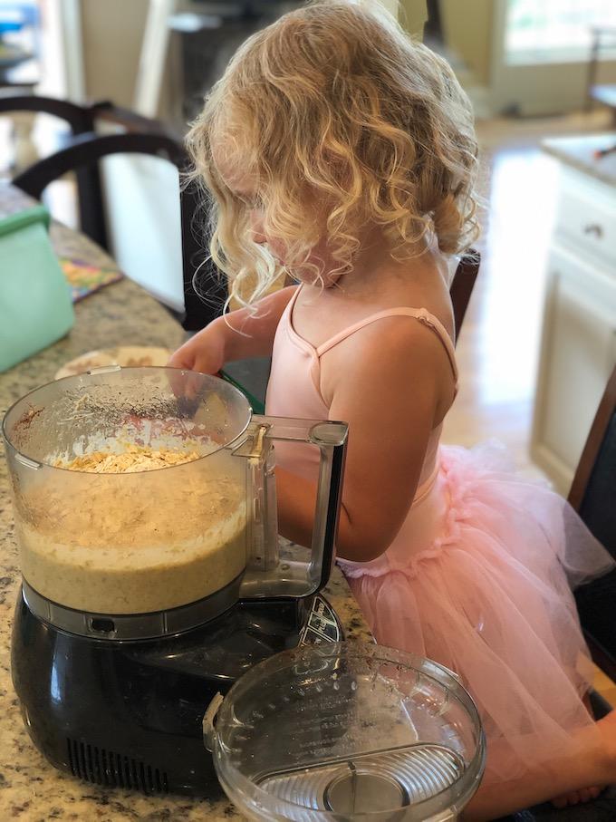 toddler making muffins with a food processor