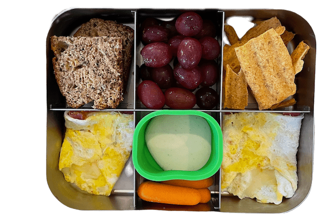 Easy Lunch Box Ideas For Kids 6 kids lunch with banana bread, egg wrap, carrots with ranch, sun chips and grapes