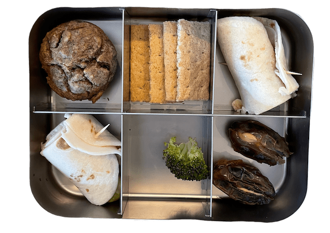 elementary lunch box with lentil banana muffin, turkey roll up, dates with peanut butter and graham crackers