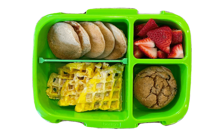 breakfast for lunch box with pancakes, egg waffle, banana carrot muffin and strawberries
