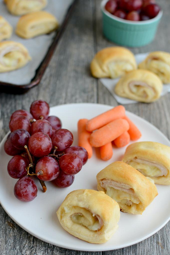warm turkey and cheese roll-ups with grapes and carrots