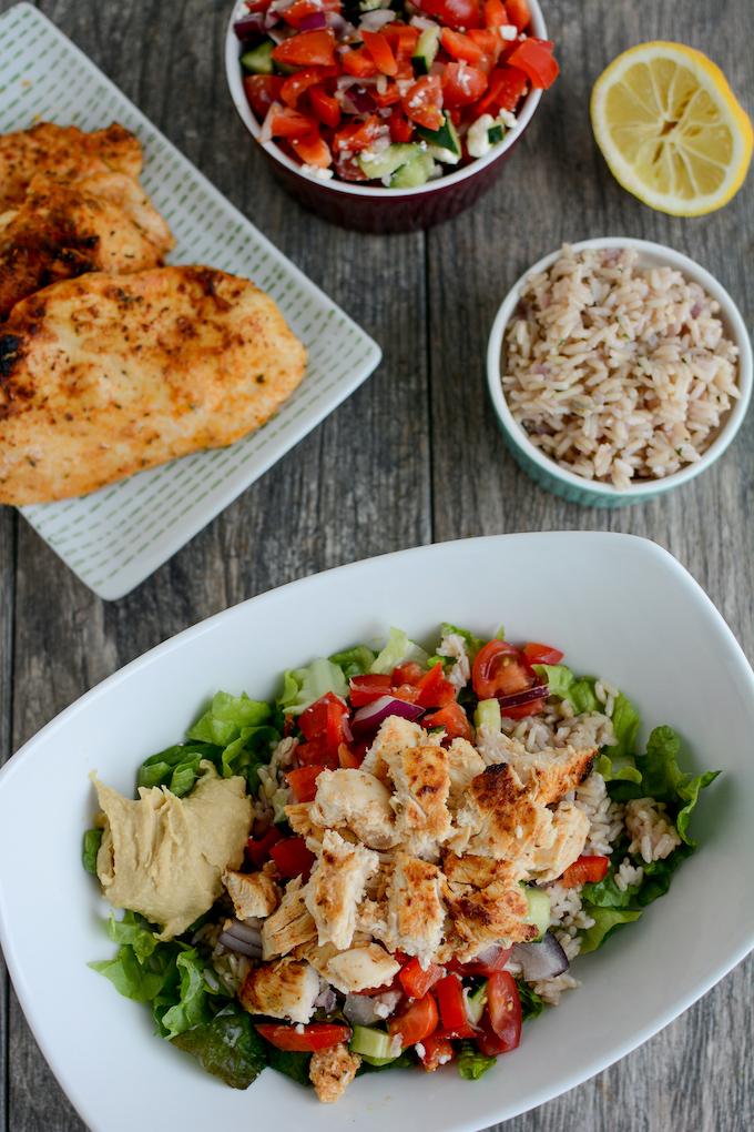 marinated meal prep chicken plated on salad with rice