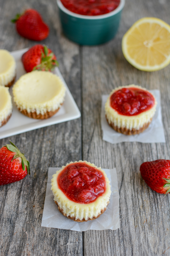 mini lemon cheesecakes with graham cracker crust and strawberry sauce